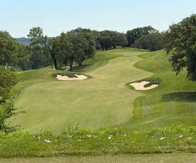 Elevated view of a rolling fairway climbing past two sand bunkers at Quarry Oaks Golf Club in Ashland, Nebraska