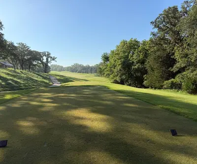 Tee box looking down a tree-lined fairway in morning light at Quarry Oaks Golf Club in Ashland, Nebraska