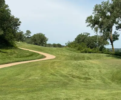 Winding cart path climbing beside a rolling tree-lined fairway at Quarry Oaks Golf Club in Ashland, Nebraska
