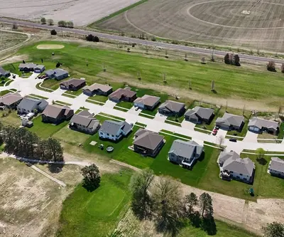 Aerial view of homes lining the fairways beside farm fields at Poco Creek Golf Course in Aurora, Nebraska