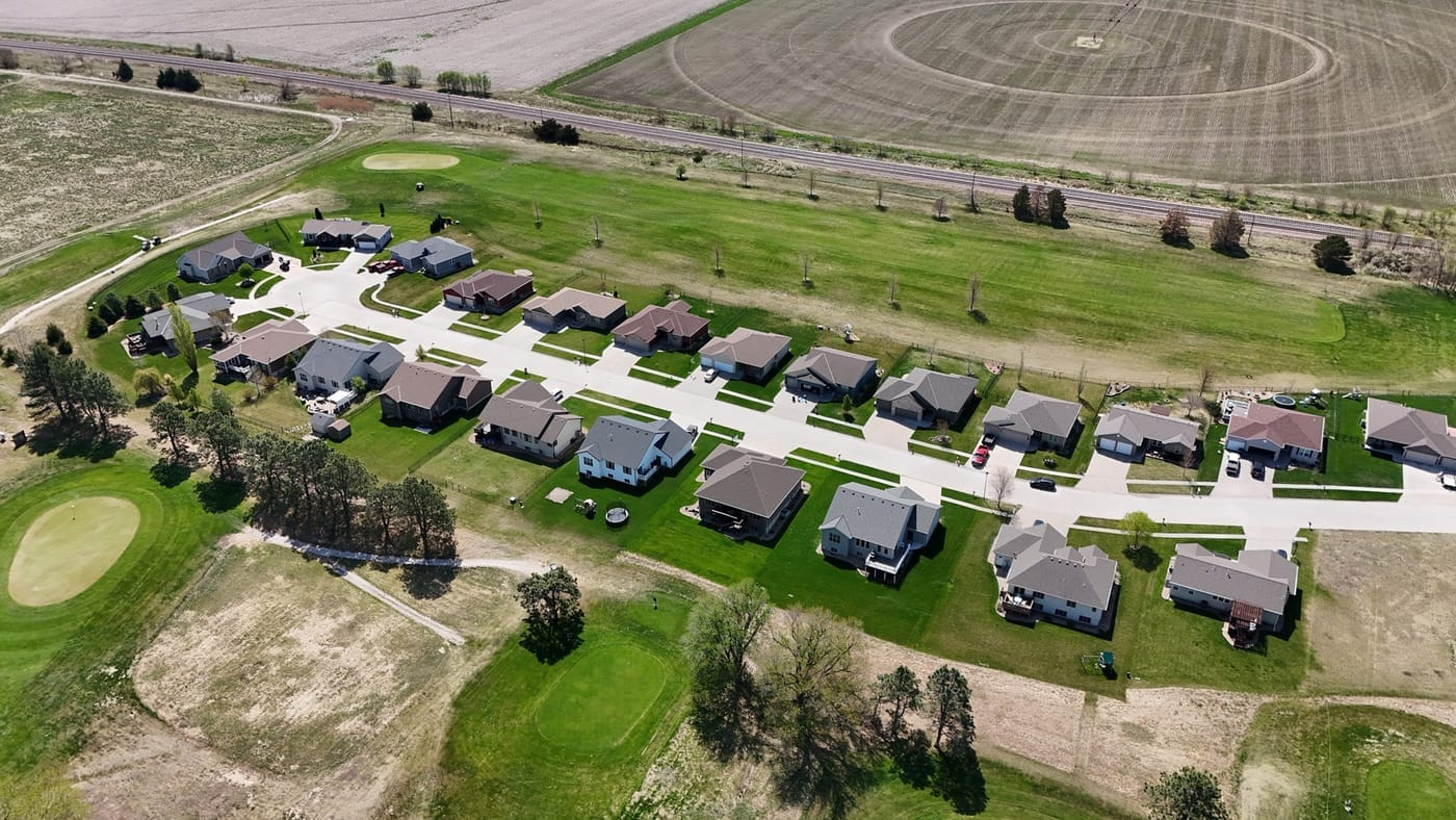 Aerial view of homes lining the fairways beside farm fields at Poco Creek Golf Course in Aurora, Nebraska