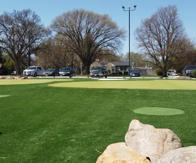 Artificial turf putting greens with boulders near the parking lot at Poco Creek Golf Course in Aurora, Nebraska