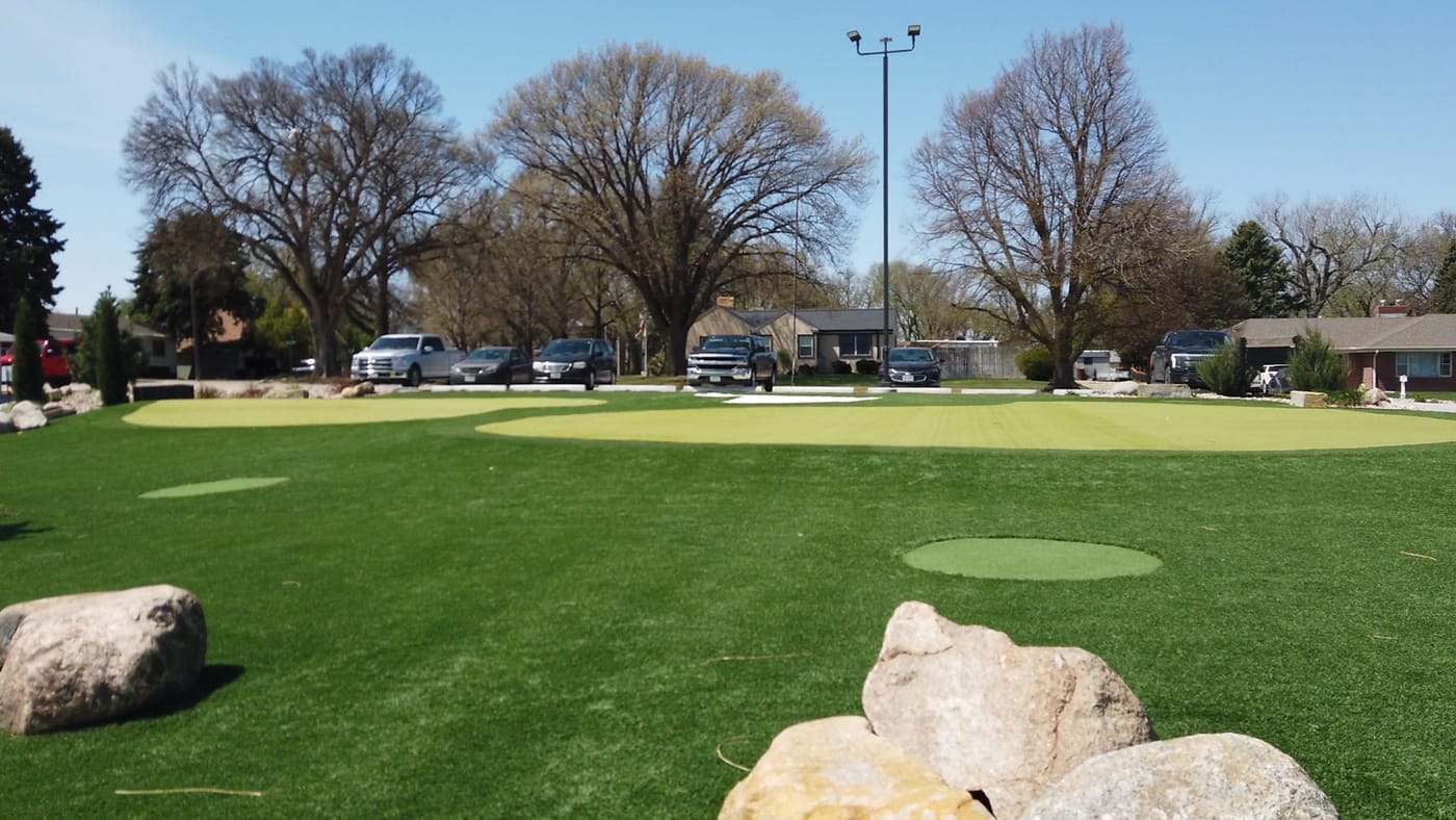 Artificial turf putting greens with boulders near the parking lot at Poco Creek Golf Course in Aurora, Nebraska