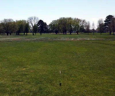 Wide fairway leading toward a line of mature trees in spring at Poco Creek Golf Course in Aurora, Nebraska