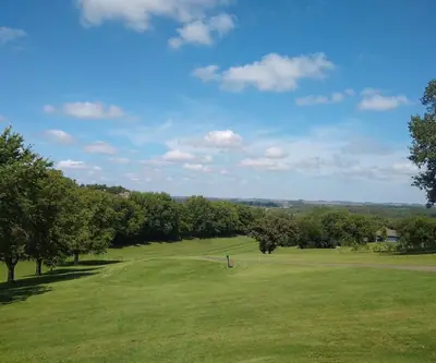 Elevated tee overlooking tree-lined fairways and a wide valley at Indian Trails Country Club in Beemer, Nebraska