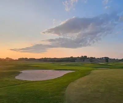 Sunset over a flagged green and sand bunker at Cross Creek Golf Links in Cambridge, Nebraska