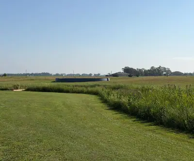 Mowed fairway curving along tall native grass toward a steel ring at Dannebrog Country Club in Dannebrog, Nebraska