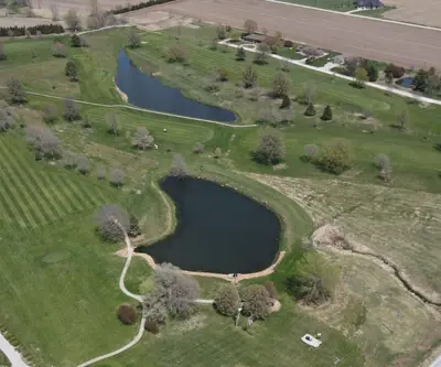 Aerial view of two ponds among tree-lined fairways and farm fields at Falls City Golf Course in Falls City, Nebraska