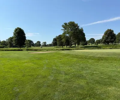 Approach to a green with a greenside bunker and mature trees at Southern Hills Golf Club in Hastings, Nebraska