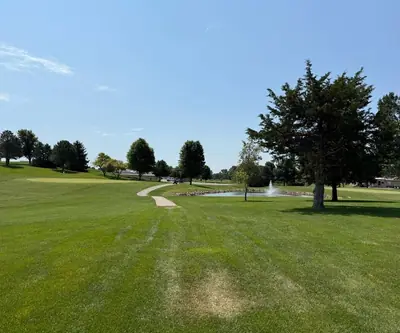 Fairway and cart path leading toward a green and a fountain pond at Southern Hills Golf Club in Hastings, Nebraska