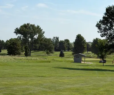 Open fairway with a small shelter and a golf cart among mature trees at Southern Hills Golf Club in Hastings, Nebraska