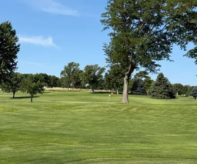 Rolling fairway leading to a flagged green framed by tall trees and spruces at Southern Hills Golf Club in Hastings, Nebraska