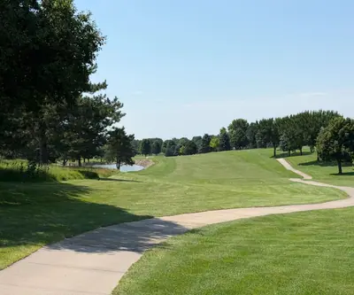 Winding cart path beside a sunny fairway with a pond in the distance at Southern Hills Golf Club in Hastings, Nebraska