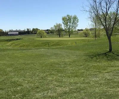 Roped-off green on a low rise framed by spring trees at Elks Country Golf Course in Kearney, Nebraska