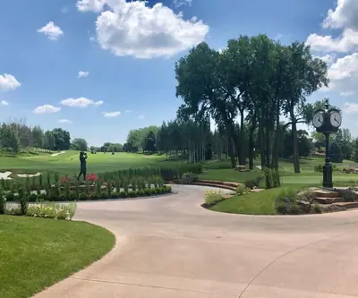 Golfer silhouette sculpture, clock post and landscaped drive at Shadow Ridge Country Club in Omaha, Nebraska