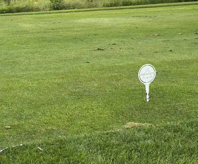 Tee marker with The Greens logo on a tee box at The Greens At Prairie Hills in Pleasanton, Nebraska