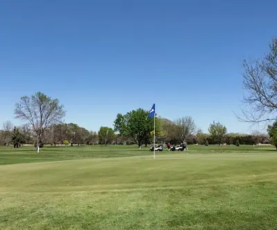 Green with a blue flag and golf carts in the distance at St. Paul Country Club in St. Paul, Nebraska